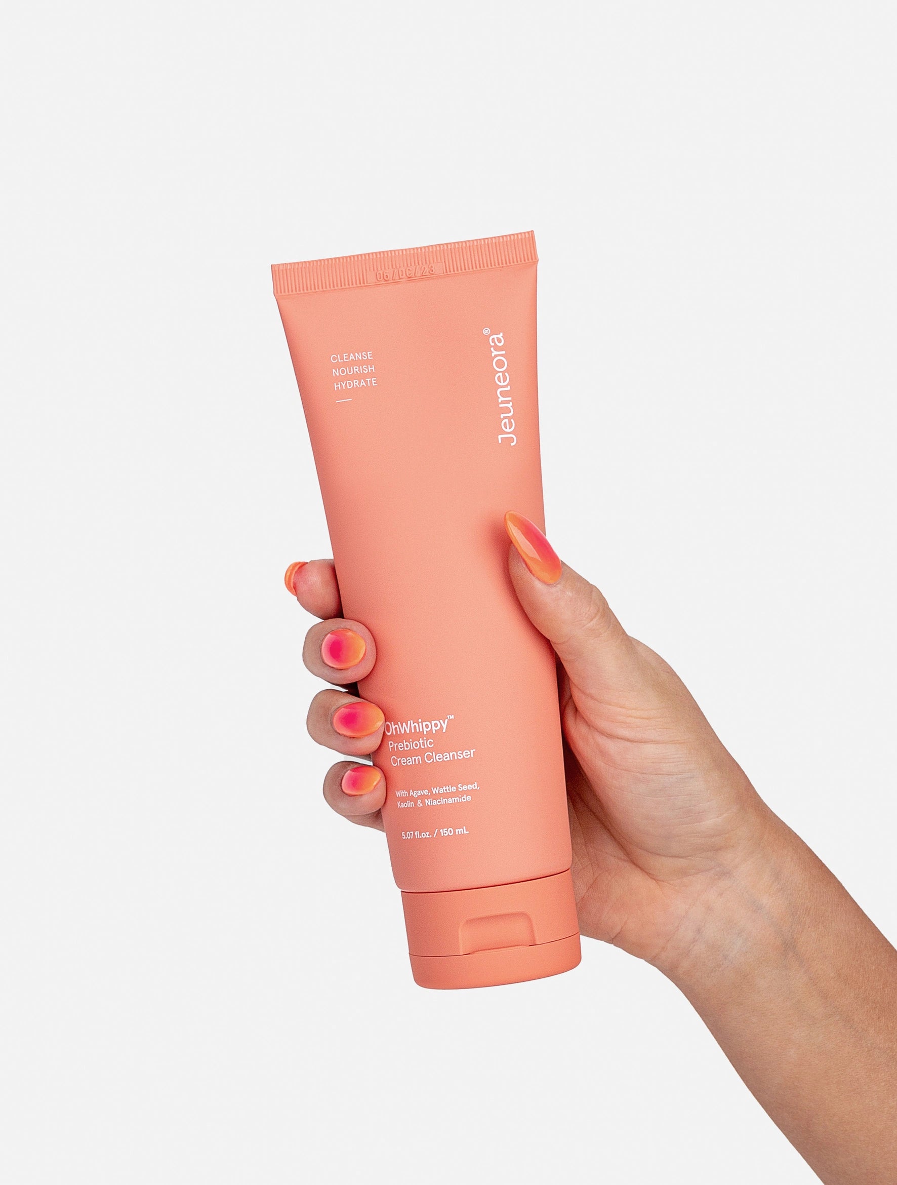 A hand holds an OhWhippy Prebiotic Cream Cleanser