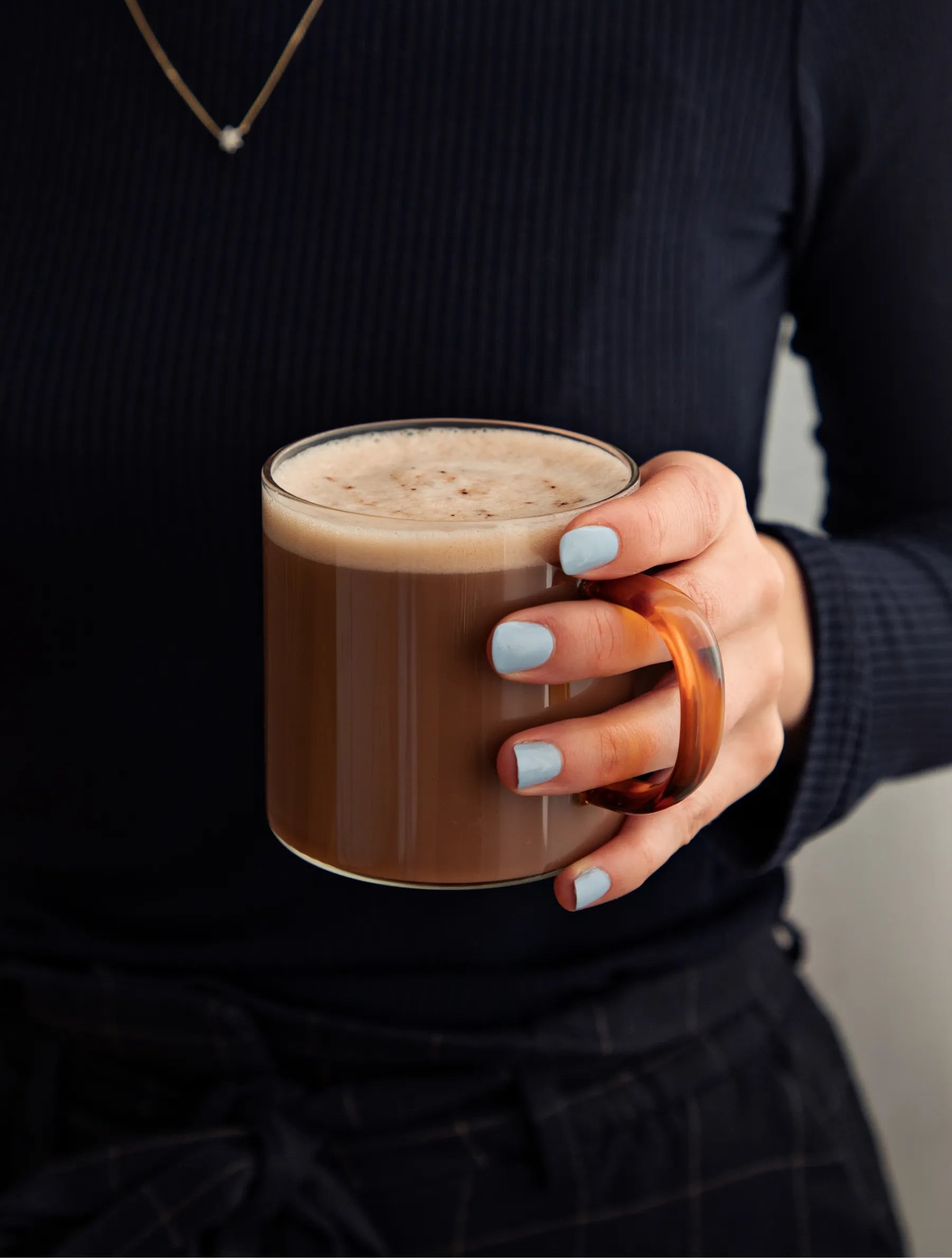 A woman holds a hot mug of hot chocolate Beauty Sleep supplement